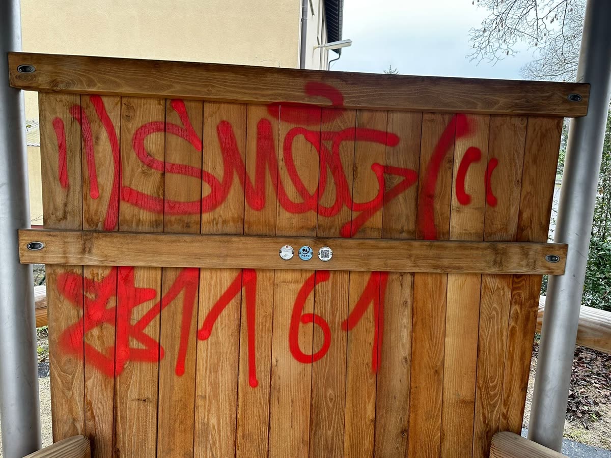 Vorher: Rotes Graffiti auf Holzwand